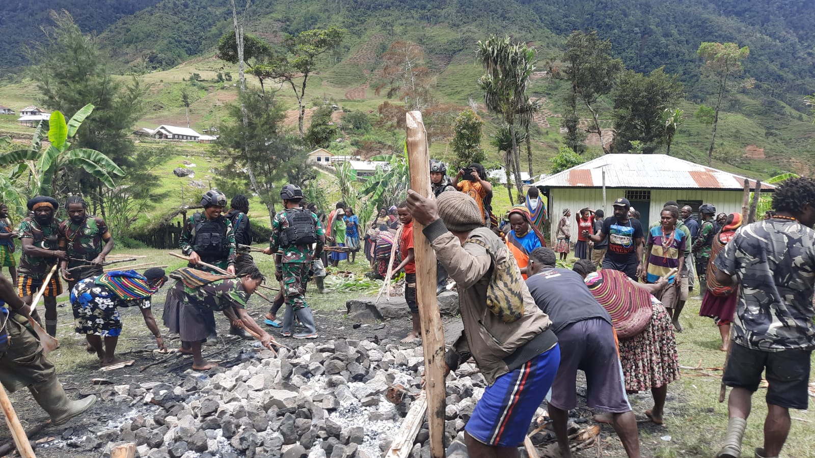 Satgas Yonif RK 114/SM Bakar Batu Bersama Masyarakat